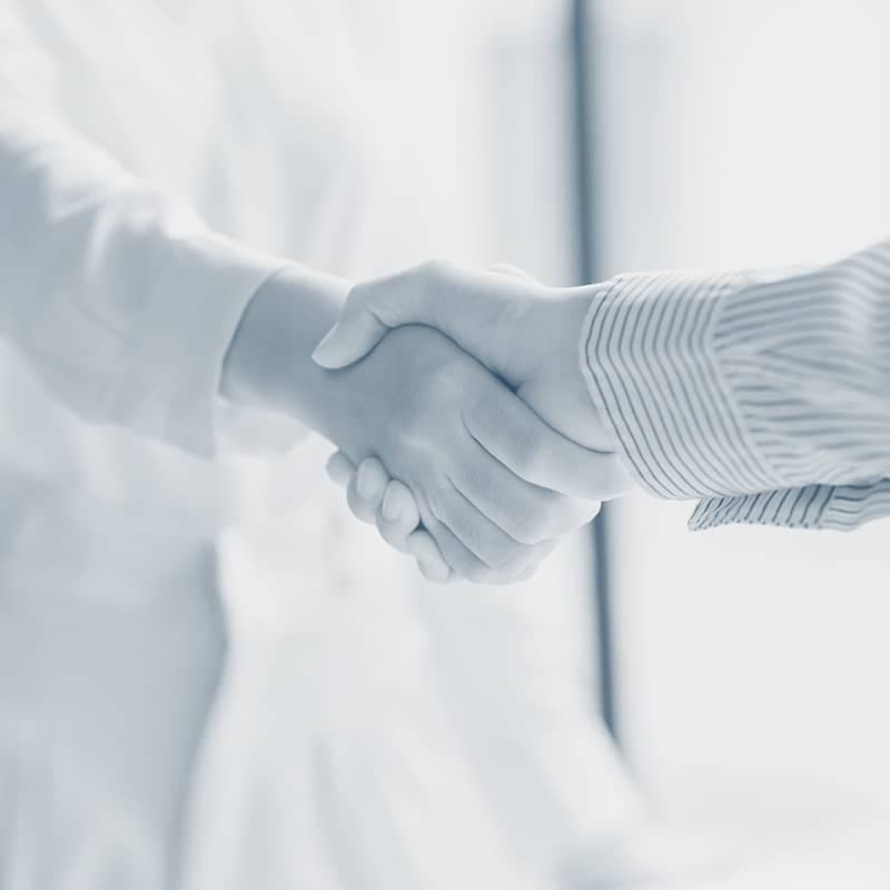 Aperto de mão entre duas pessoas a fechar um acordo